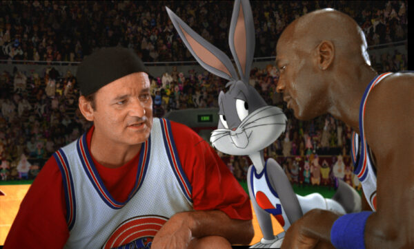 UNSPECIFIED - JANUARY 26: Medium shot of Bill Murray as Himself wearing hat/baseball cap, huddled with Bugs Bunny and Michael Jordan; all wearing basketball uniforms in front of crowd. (Filmframe). (Photo by Warner Bros./Getty Images)