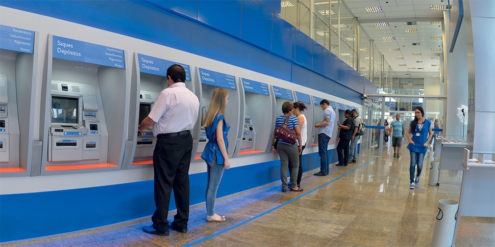 Foto de gerente de banco sentado no chão para atender cliente com deficiência viraliza
