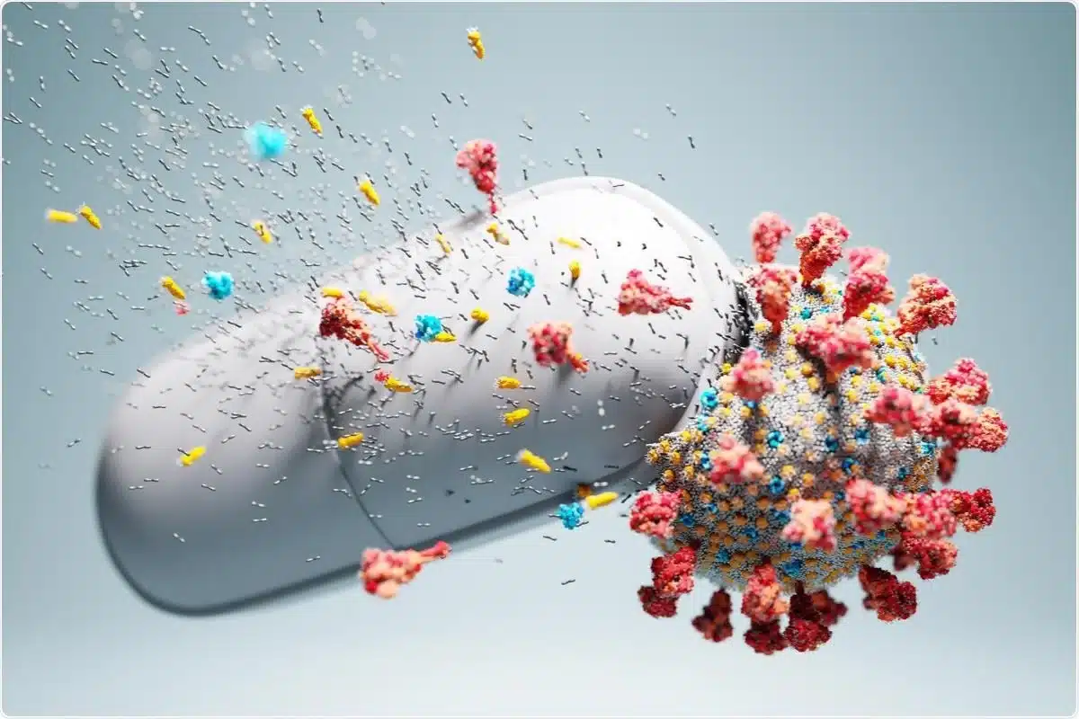 Comprimidos de antiviral ao lado de microscópio e representação do vírus SARS-CoV-2
