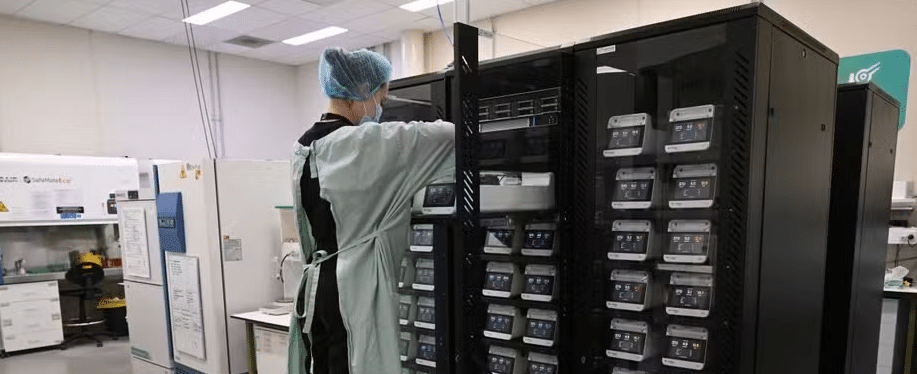 Nesta foto tirada em 5 de maio de 2026, a cientista pesquisadora Daria Kornienko posiciona uma unidade CL1 contendo células corticais e do hipocampo em uma placa de cultura celular, instalada em racks de servidores e disponível para estudo via internet no laboratório de Nível 2 de Contenção Física (PC2) da Cortical Labs, em Melbourne. — Foto: AFP